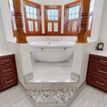 master bathroom jacuzzi tub with his and her sinks to left and right